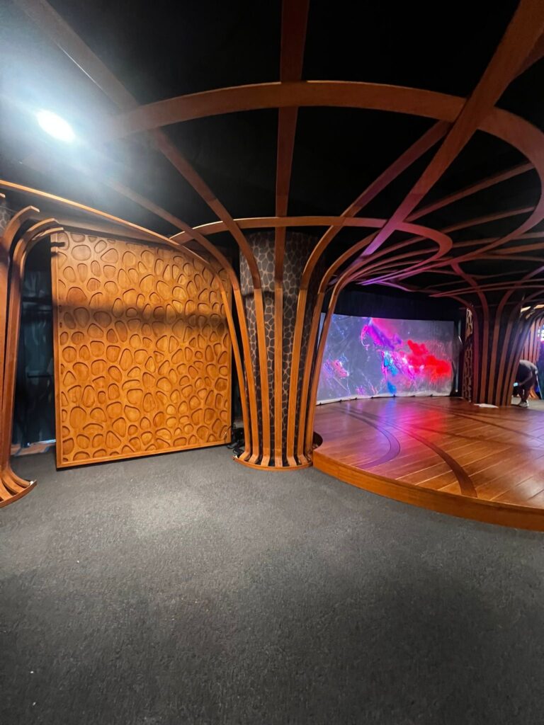 Custom scenic tv studio with curved beams and carved wall panels.