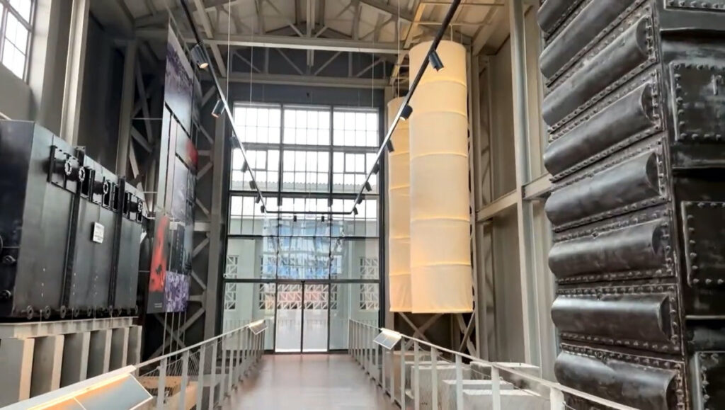 Interior view of a museum installation featuring a large stainless steel structure and scenic elements fabricated by Alice Scenic Studios.