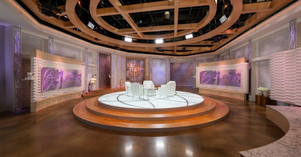 Broadcast studio set design for the Better Together TV show with circular platform, suspended ceiling feature and white chairs